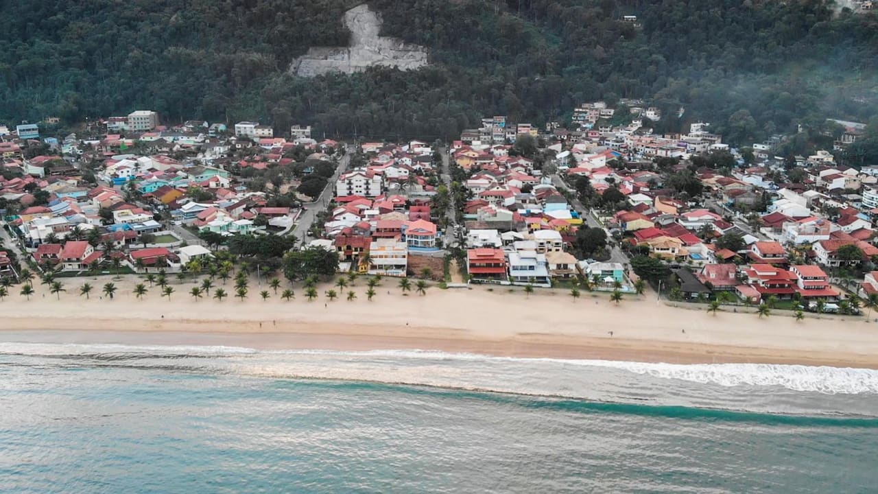 Vista aérea da praia de Garatucaia, em Angra dos Reis, com a faixa de areia, o mar e a serra